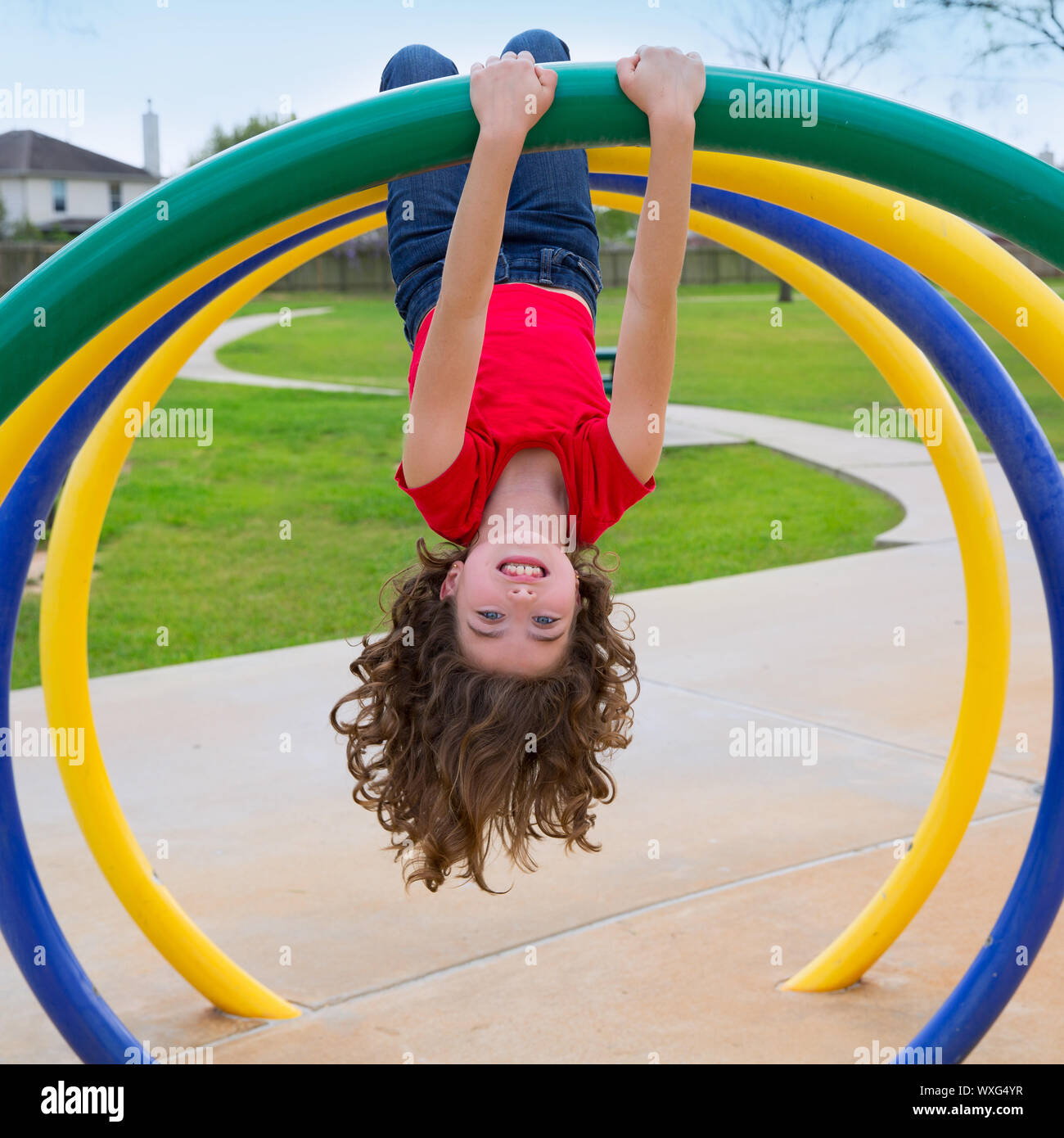 Kinder Kind Mädchen auf dem Kopf stehend auf einem Park Spielplatz Ring game Stockfoto