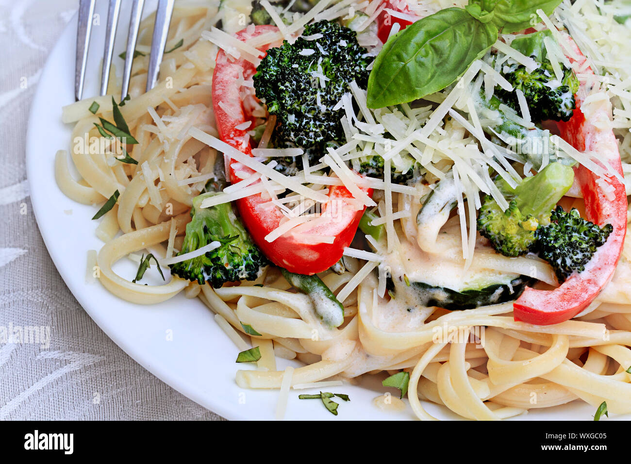 Pasta Primavera mit frischen Brokkoli, Spargel, rote Paprika und Zucchini mit frisch geriebenem Parmesan. Stockfoto