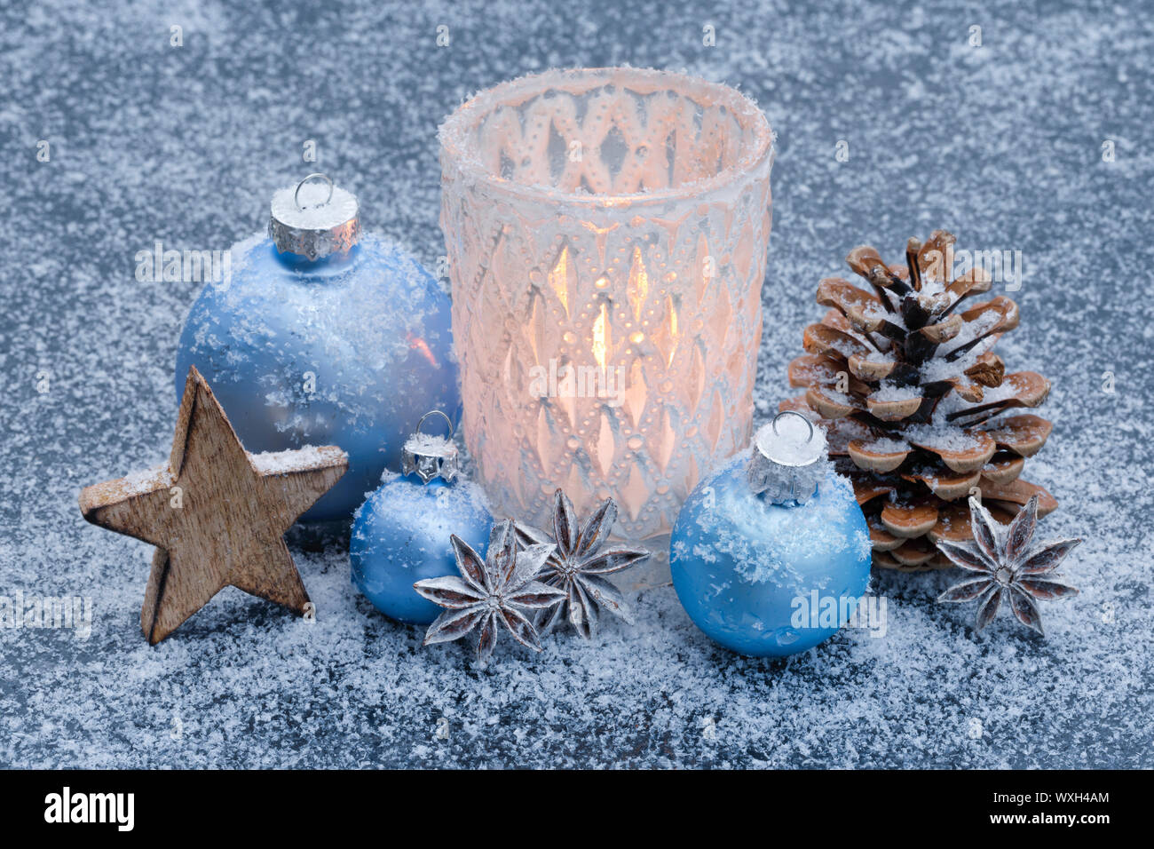 Natürliche advent dekoration: eine brennende Kerze in einem stom Lampe im  Schnee, durch Licht blaue Kugeln umgeben. Schweiz Stockfotografie - Alamy