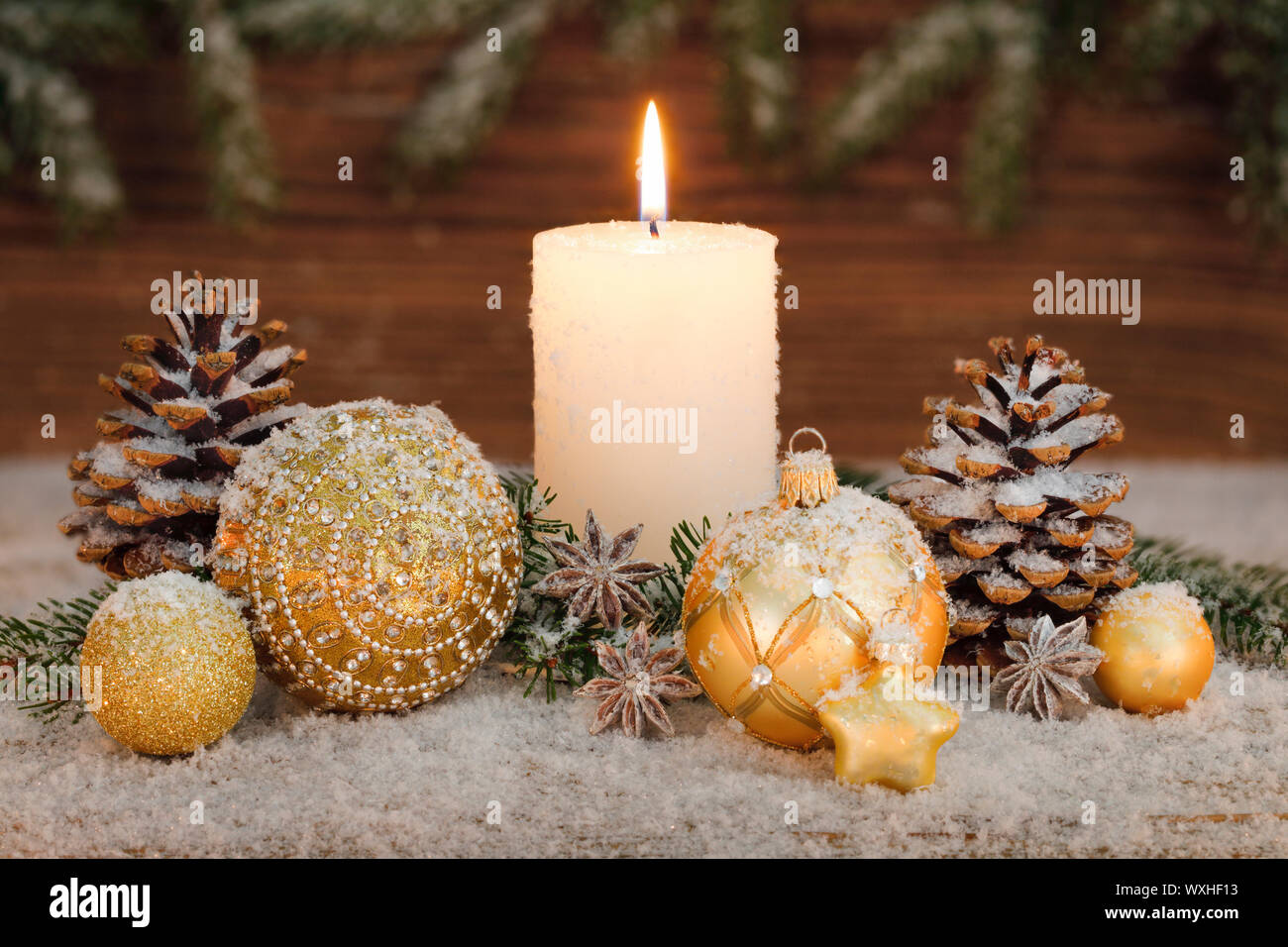 Weihnachten Dekoration: Brennende Kerze mit goldenen Christbaumkugeln und  Tannenzapfen. Schweiz Stockfotografie - Alamy