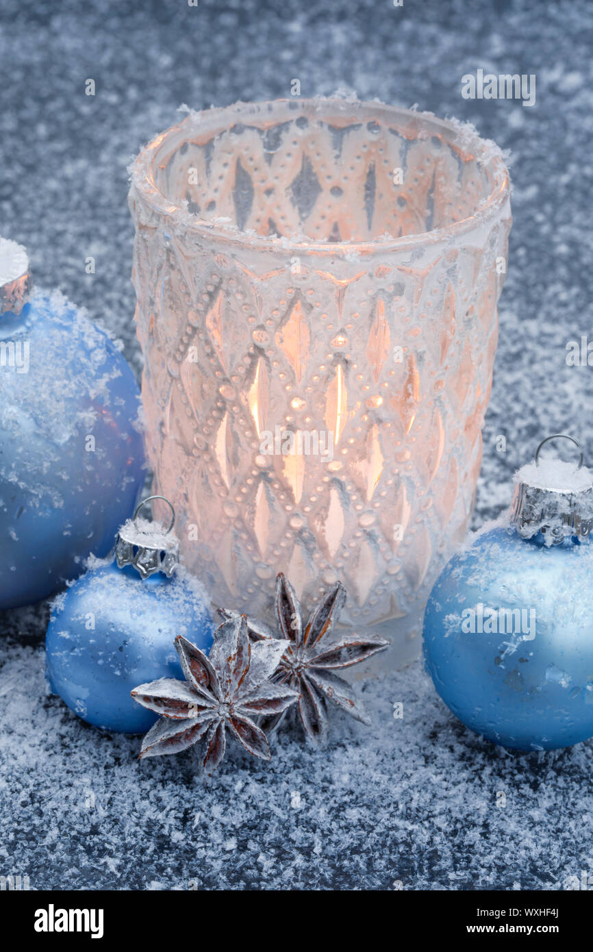 Natürliche advent dekoration: eine brennende Kerze in einem stom Lampe im  Schnee, durch Licht blaue Kugeln umgeben. Schweiz Stockfotografie - Alamy