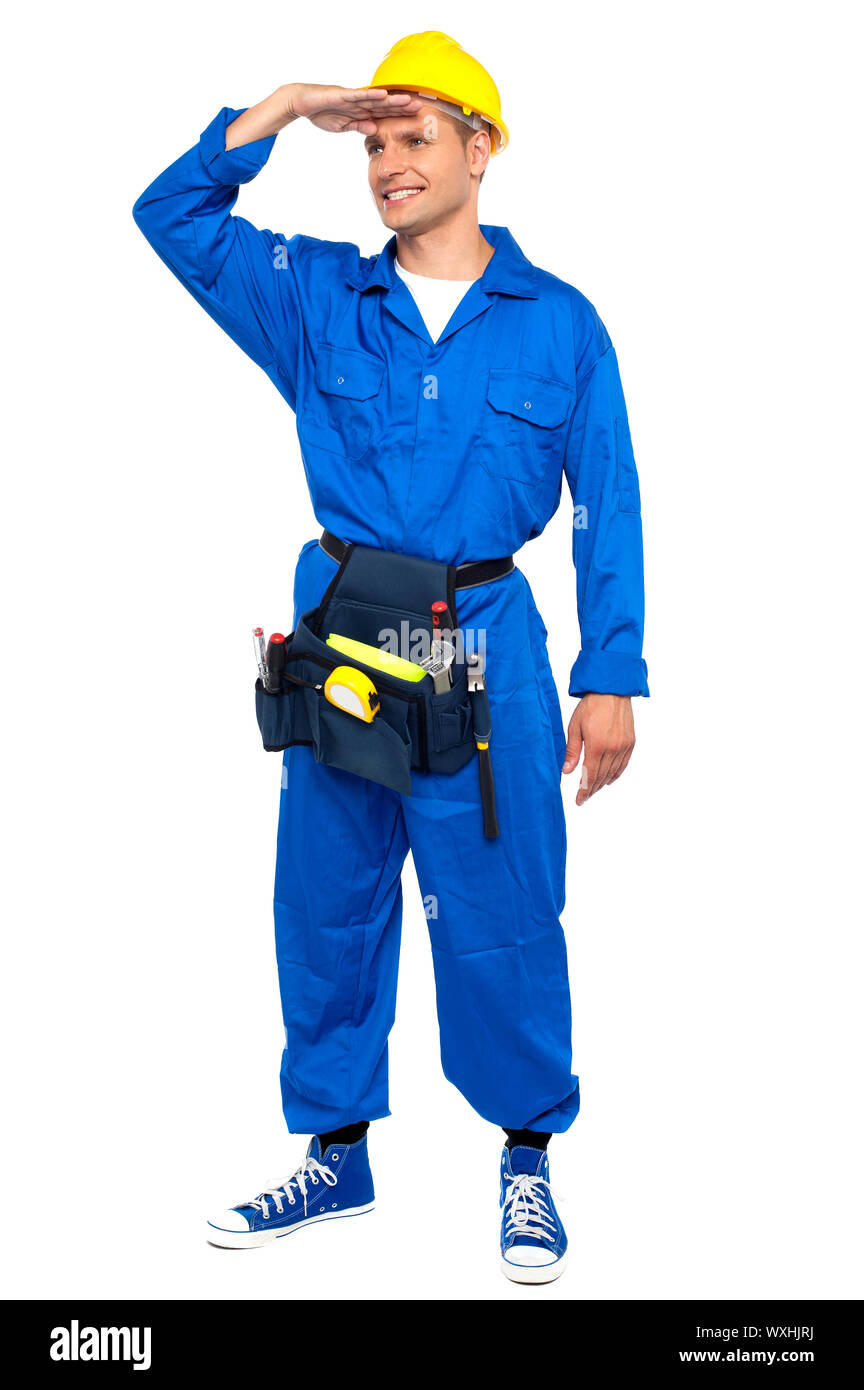 Junge attraktive Handwerker freut sich mit einer Nebenhand Verwendung als Schutzschild Stockfoto