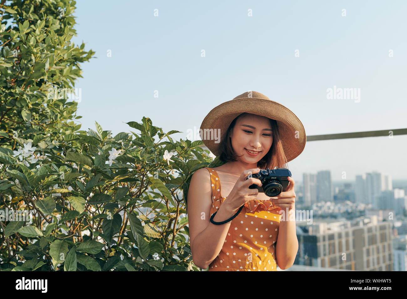 Junge asiatische Mädchen steht auf dem Dach und Kamera verwenden. Sommer Konzept. Stockfoto