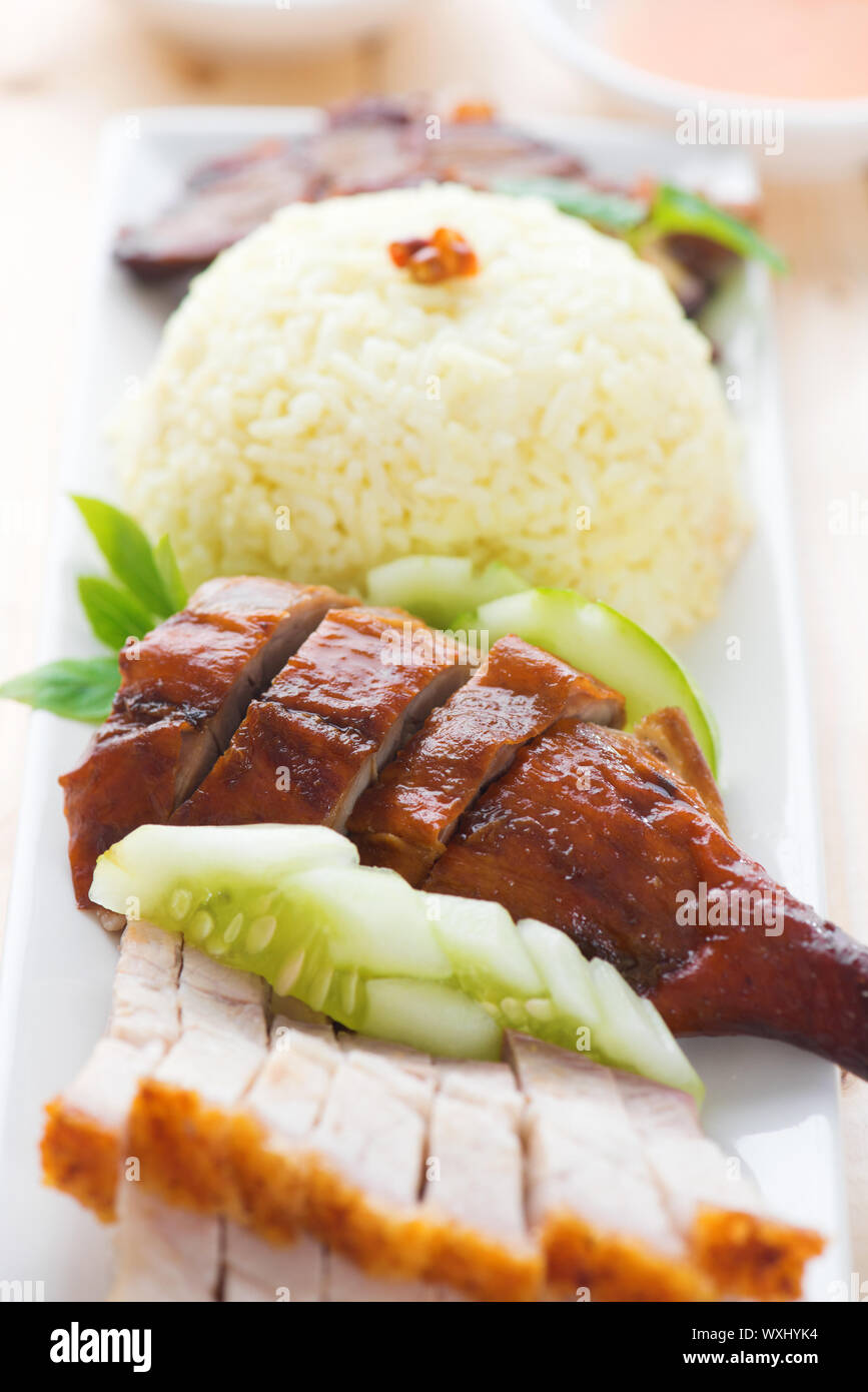 Gebratene Ente und knusprig gebratenes Schweinefleisch Siu Yuk, im chinesischen Stil, mit Reis auf Esstisch serviert. Malaysia-Küche. Stockfoto