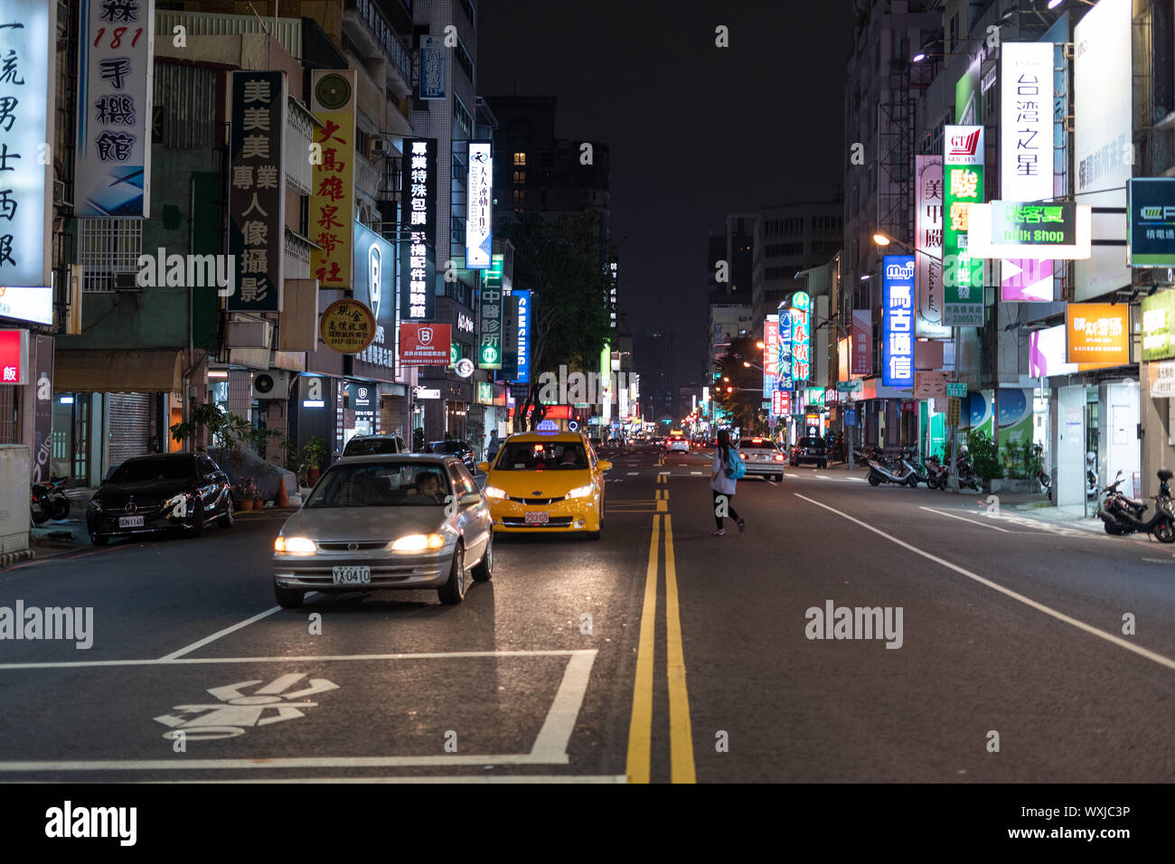 Kaohsiung, Taiwan - 07 April 2019: Verkehr auf Urban Street in der Nacht beleuchtet durch bunte Werbung Leuchtreklame mit chinesischen Schriftzeichen. Stockfoto