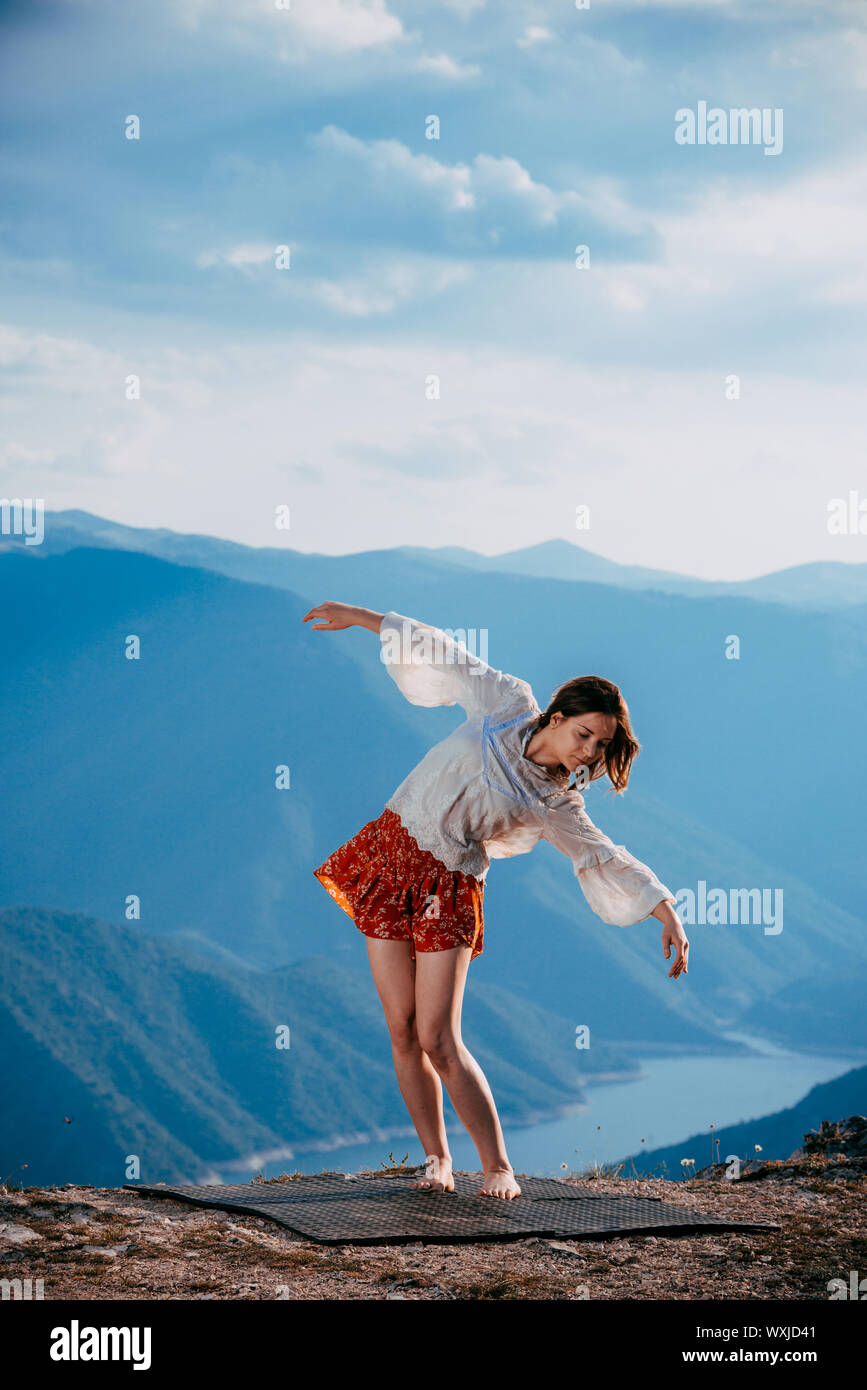 Silhouette einer schönen weiblichen Ballett Tänzerin beim Tanzen gegen den blauen Himmel cloduy Stockfoto