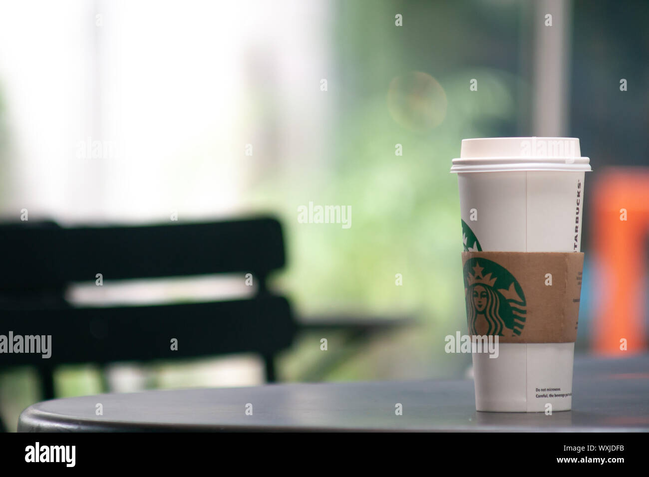 Bangkok, Thailand - Sep 1, 2019: eine große Tasse Starbucks Kaffee auf dem Tisch im Freien. Starbucks nehmen Kaffeetasse mit Logo, bokeh Innenraum backgrou Stockfoto