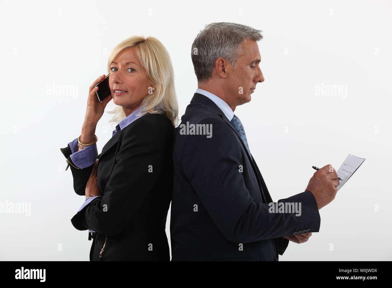 Reife Geschäftsmann und weiblichen Partner stehen Rücken an Rücken Stockfoto