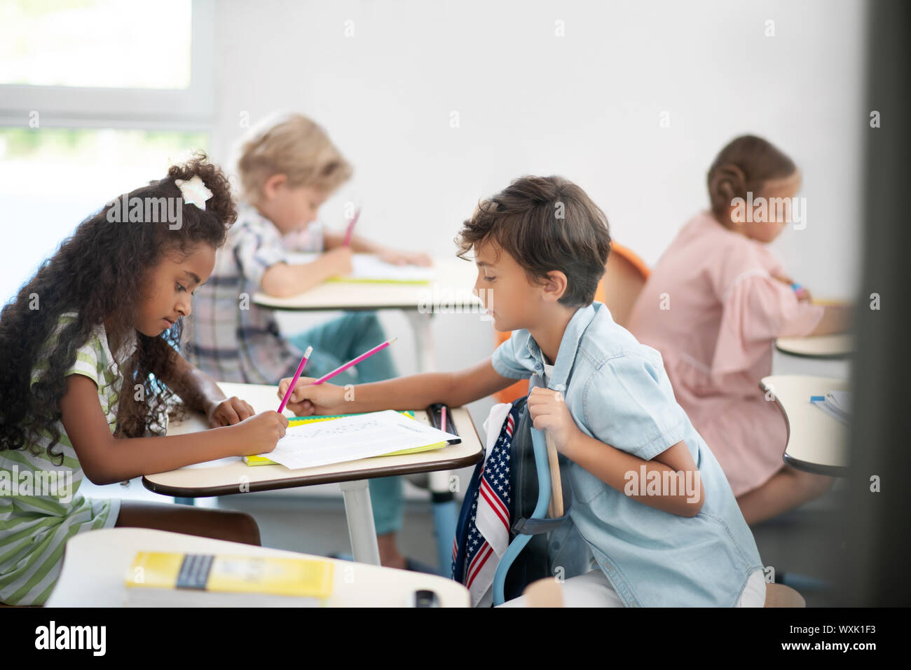 Süße Junge seinen Freund mit schwierigen Mathetest helfen Stockfoto