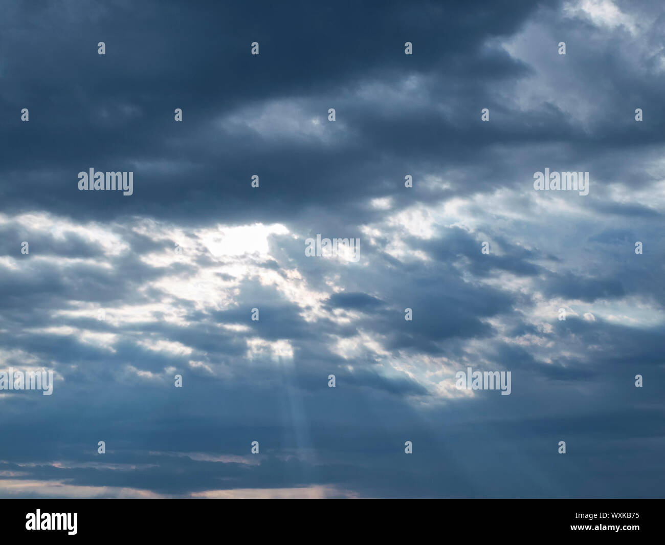 Sonnenstrahlen brechen durch die Wolken am Morgen. Dramatische Morgenhimmel. Stockfoto