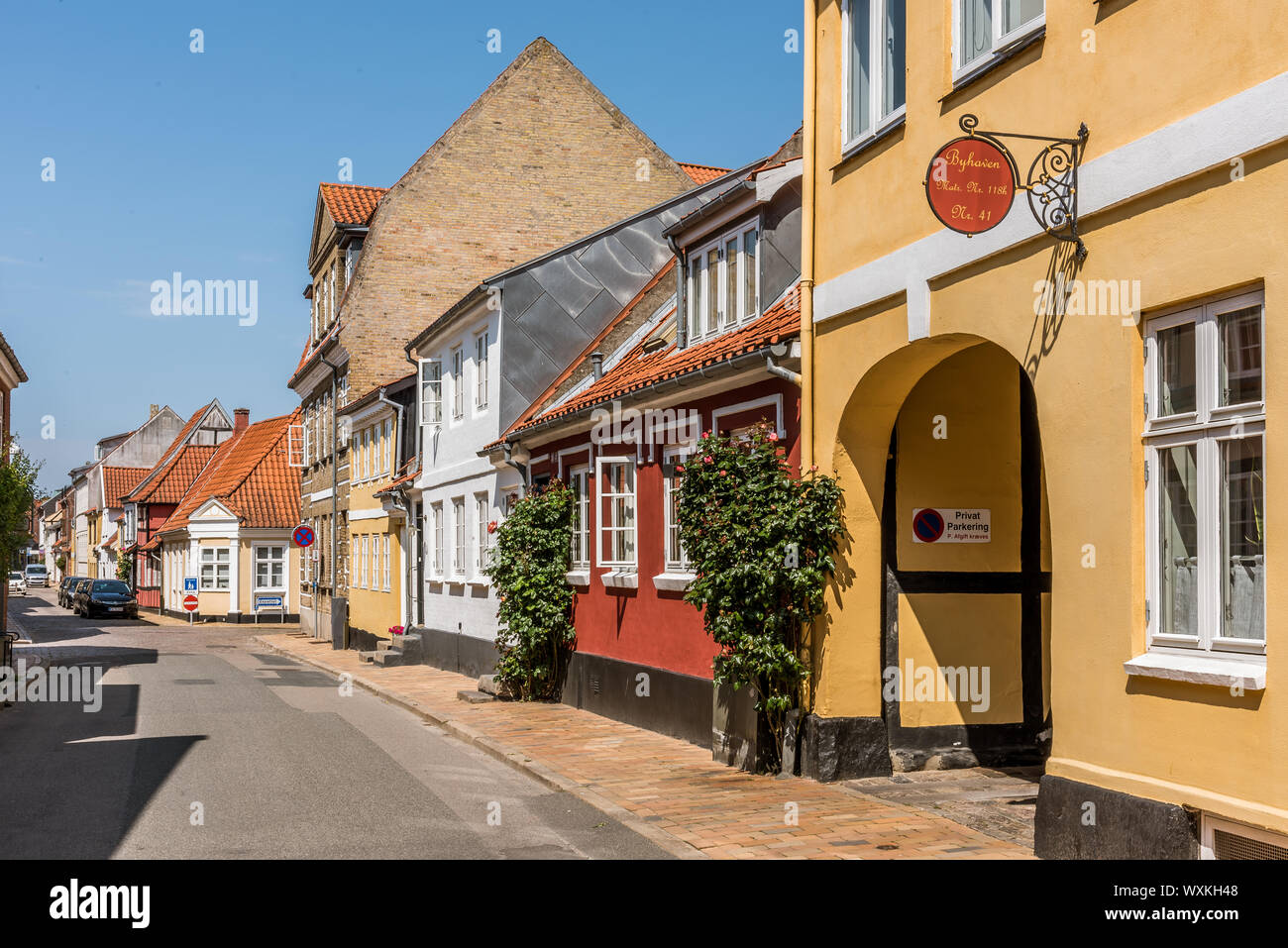 Malerische Straße in Faaborg mit alten Häusern und stockrosen auf dem Bürgersteig, Faaborg, Dänemark, 12. Juli 2019 Stockfoto
