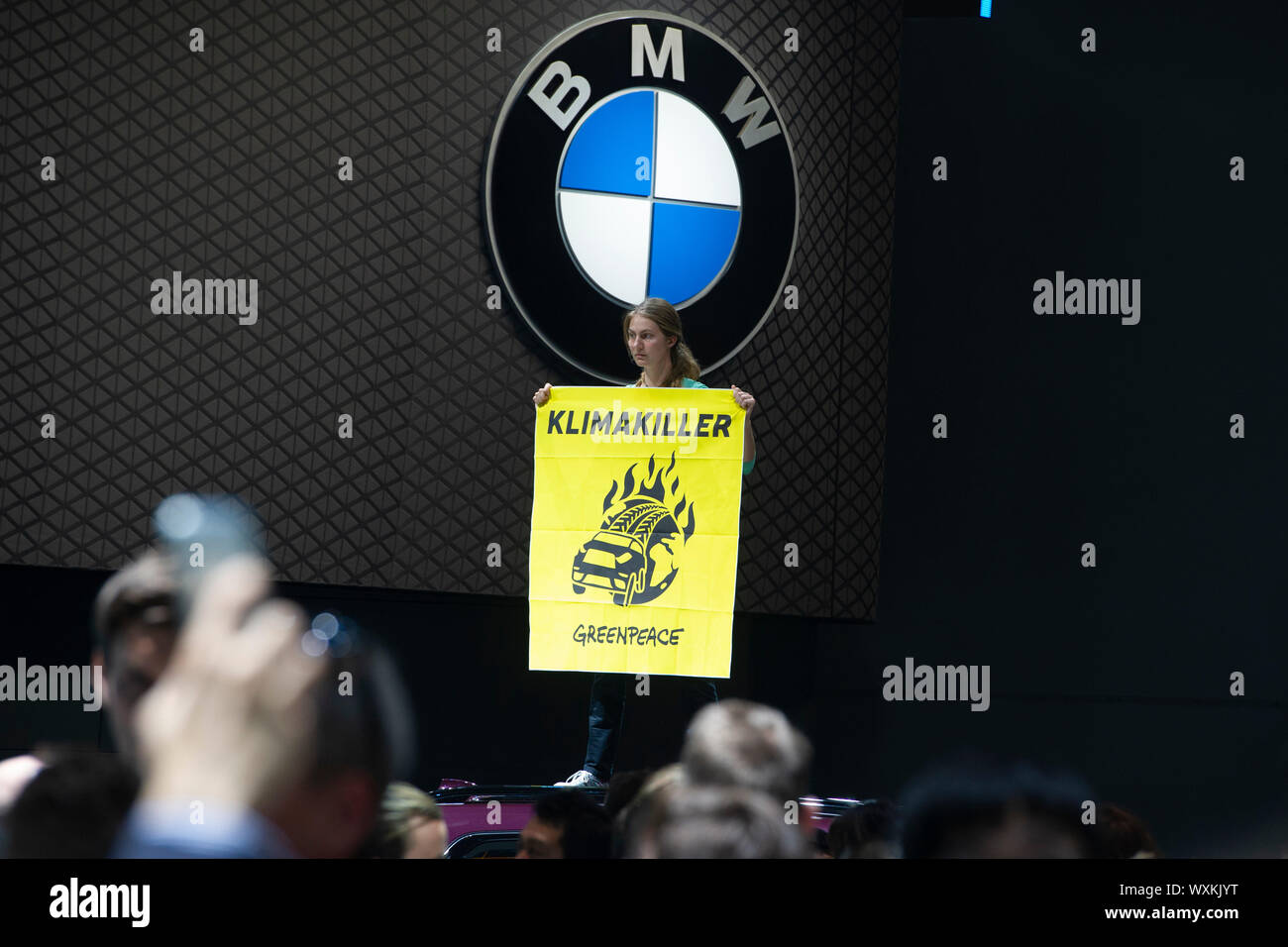 Frankfurt, Deutschland. 12 Sep, 2019. Protest von Greenpeace Aktivisten stehen auf Autos von BMW und Abrollen KLIMAKILLER Plakate, Öffnung der internationalen Automobilausstellung IAA 2019 in Frankfurt, am 12.09.2019. | Verwendung der weltweiten Kredit: dpa/Alamy leben Nachrichten Stockfoto