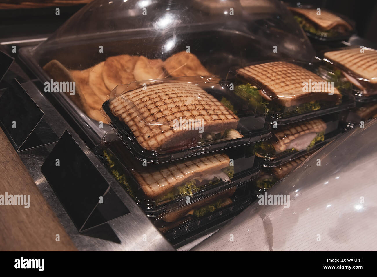 Gegrillte Sandwiches mit Hähnchen und Salat in der Kunststoffbehälter. Lecker Fuß im Lebensmittelgeschäft. Bereit zum Abendessen. Stockfoto