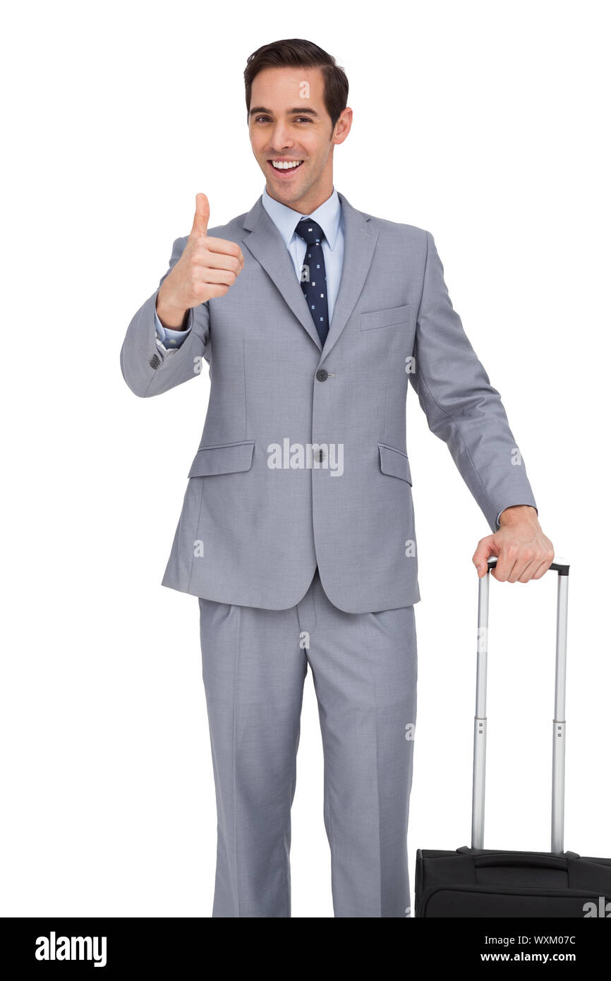 Lächelnd Geschäftsmann mit Koffer auftauchend seinen Daumen auf weißem Hintergrund Stockfoto