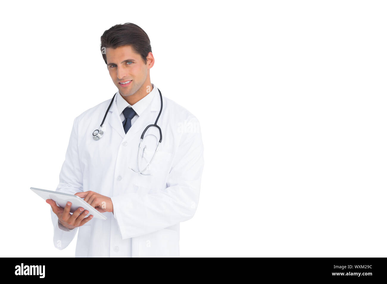 Gut aussehend Doktor mit einer Tablette auf weißem Hintergrund Stockfoto