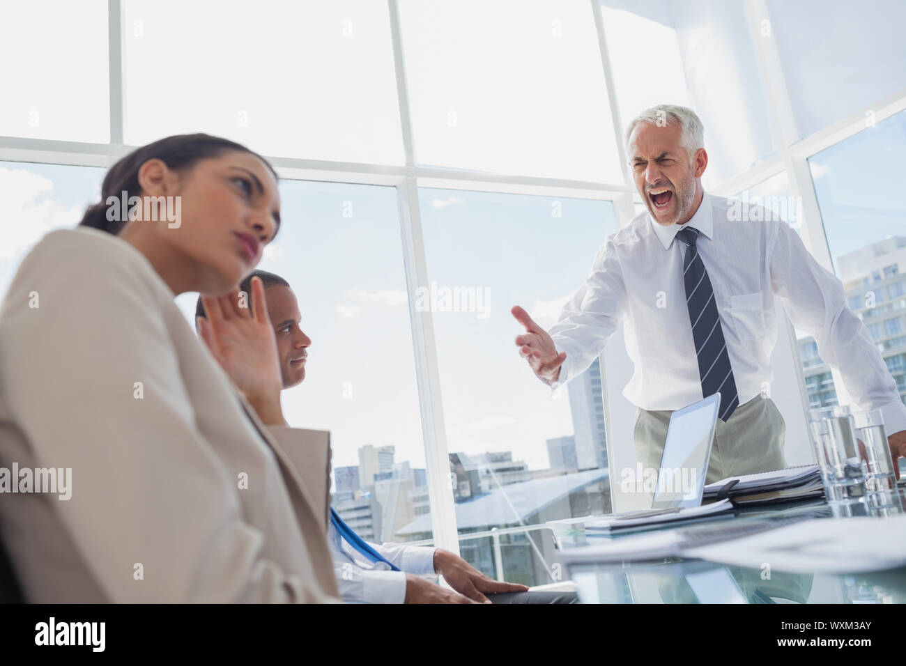 Wütende Chef anzuschreien Kollegen während eines Meetings Stockfoto