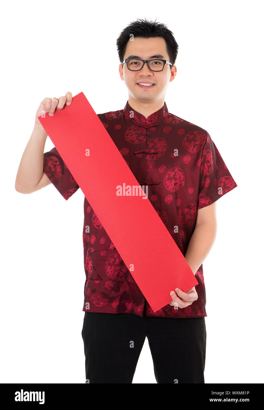 Asiatischer Mann mit chinesischen traditionellen Cheongsam oder Tang Anzug hält Couplet. Männliches Model isoliert auf weißem Hintergrund. Stockfoto