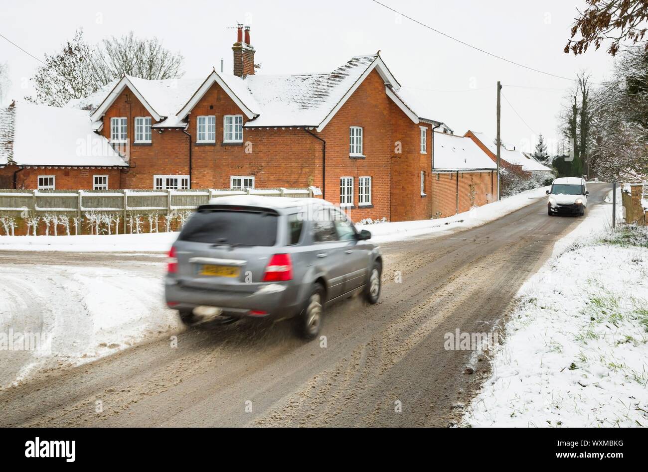 Autos fahren auf Schnee im Winter auf ländliche englische Straßen. Buckinghamshire, England, Großbritannien Stockfoto