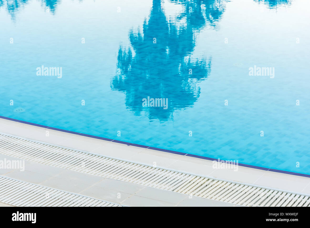 Reflexion von einer Palme im Pool einer Hotelanlage Stockfoto