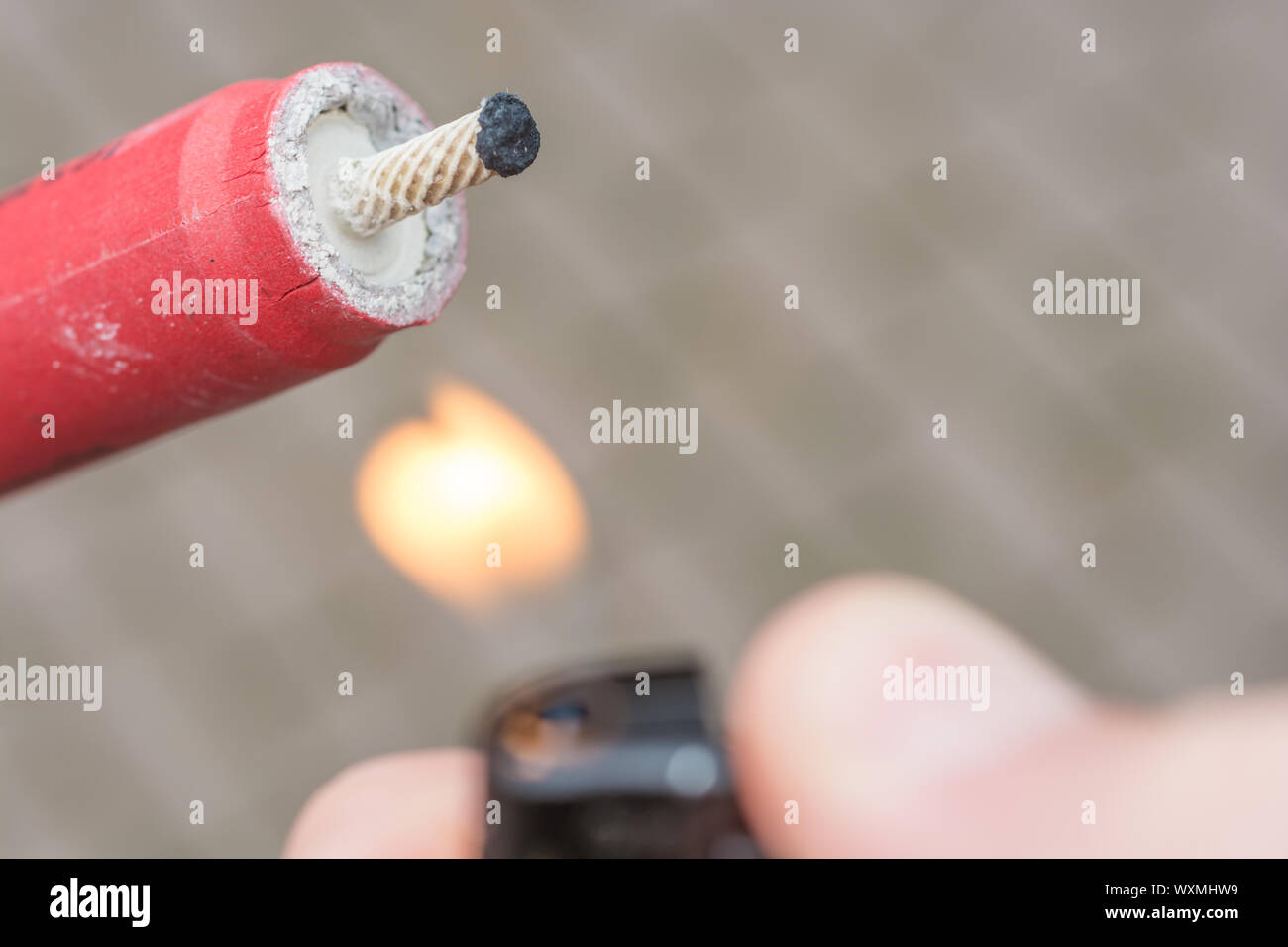 Knaller leuchtet am Silvesterabend mit einem Feuerzeug Stockfoto