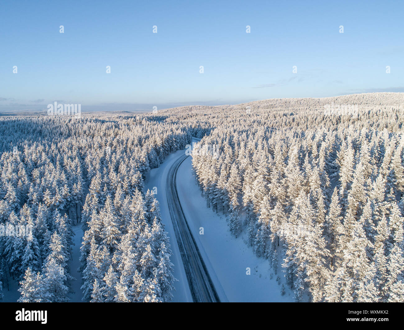Eine Autobahn überqueren der nördlichen Taiga Wald im Winter in Lappland, Finnland Stockfoto