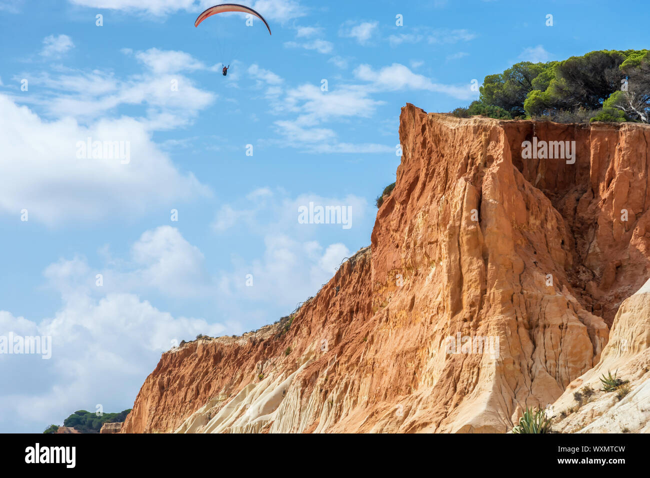 Klippen und Paraglider an der Praia de Falésia bei Albufeira in Portugal Stockfoto