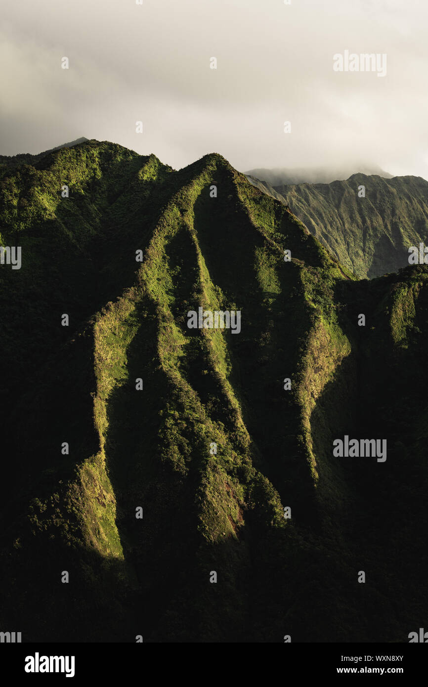 Erste Sonnenstrahlen leuchten die schöne und robuste grünen Berge von Oahu. Stockfoto