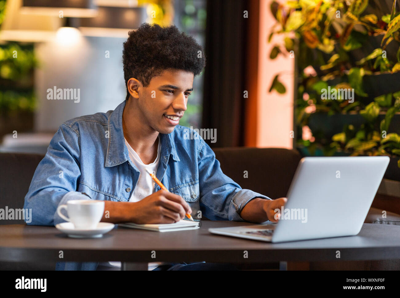 Jugendliche blogger Notizen für neue Veröffentlichung im Cafe Stockfoto