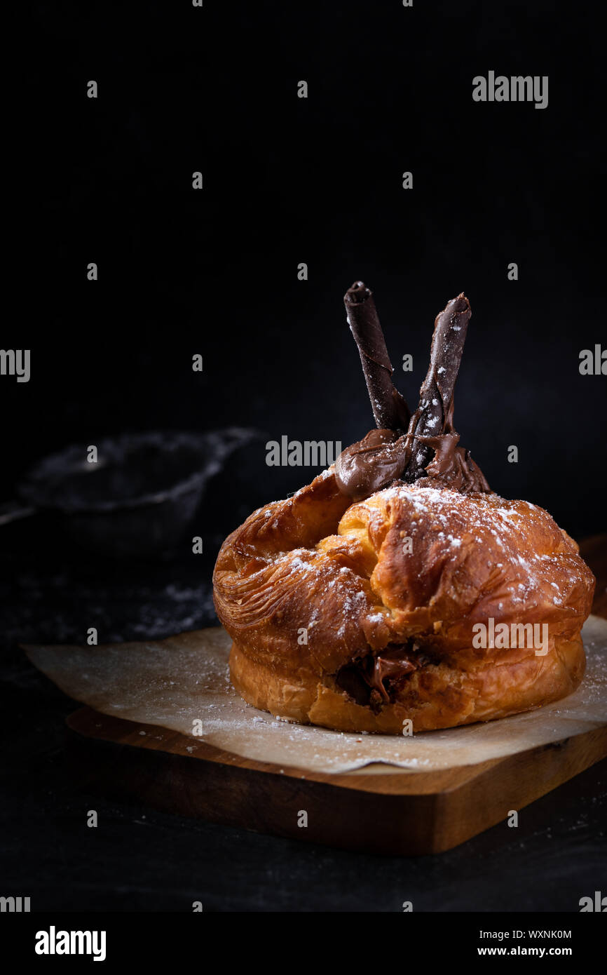 Croissant isoliert auf einem Holzbrett Stockfoto