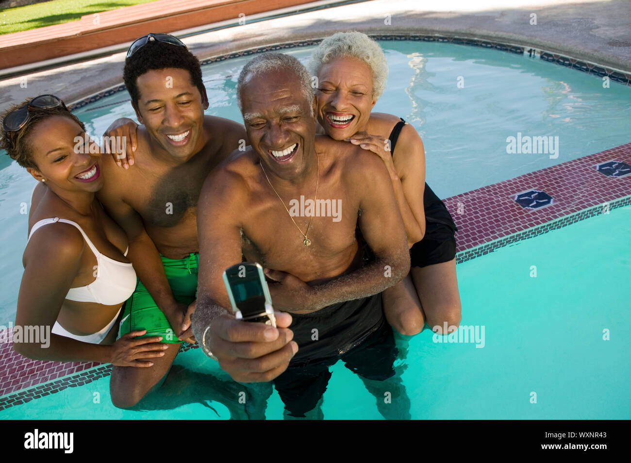 Familie posieren für Kamera Handy Bild im Pool Stockfoto