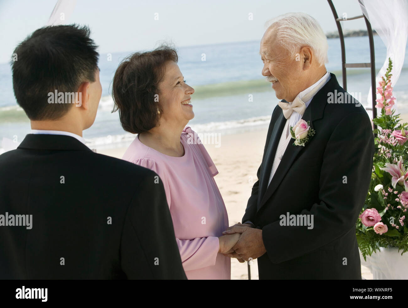 Bräutigam mit den Eltern am Strand Stockfoto