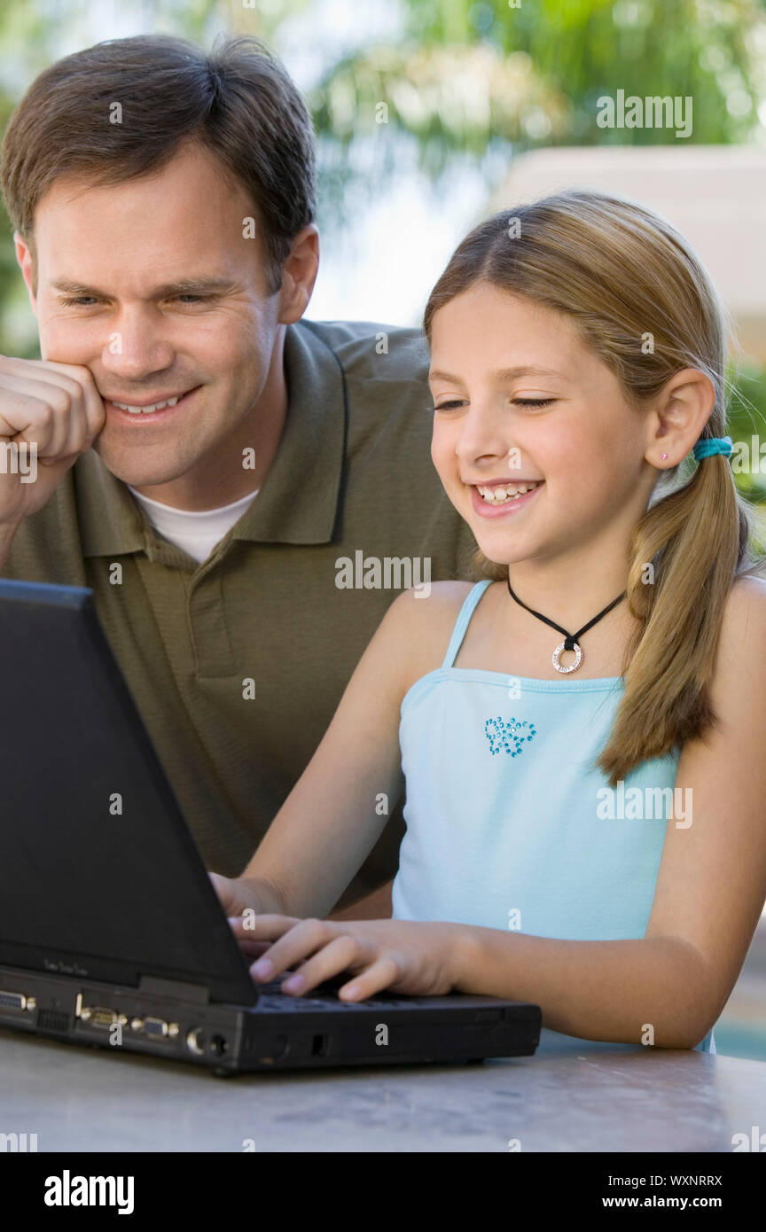 Vater beobachtete Tochter Verwendung Laptop Stockfoto