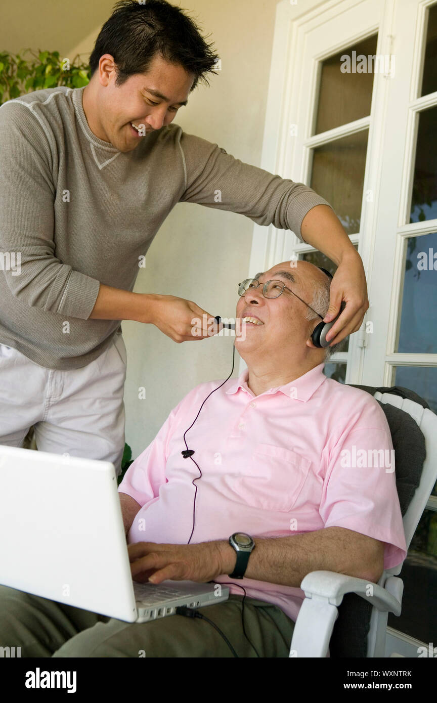 Anpassung der Kopfhörer Sohn Vater Stockfoto