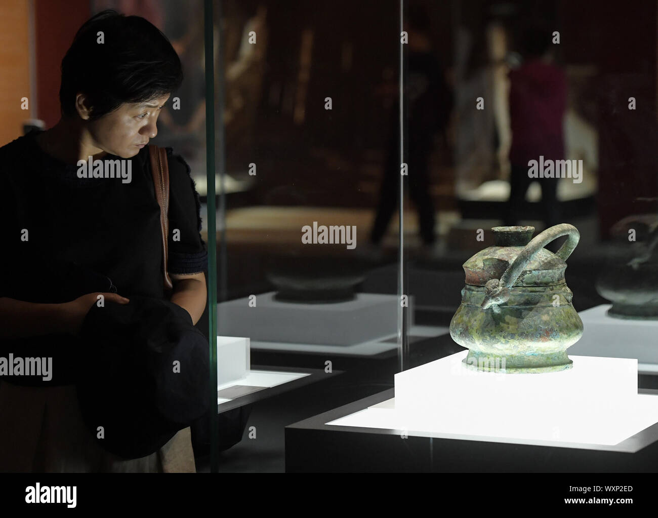 (190917)-BEIJING, Sept. 17, 2019 (Xinhua) - ein Besucher eine Ausstellung auf einer Messe präsentiert Chinas Erfolge in kulturelles Relikt Retrieval im Nationalmuseum von China in Peking, der Hauptstadt von China, Sept. 17, 2019. Mehr als 600 wertvolle kulturelle Relikte sind zu sehen in der Ausstellung als Symbol für den schwierigen, aber fruchtbaren Weg des Landes kulturelles Relikt Retrieval in den letzten sieben Jahrzehnten. In vier Abschnitte unterteilt, die Ausstellung entfaltet 25 Geschichten wie die Reliquien und Artefakte nach Hause gebracht wurden. (Xinhua/Li Er) Stockfoto