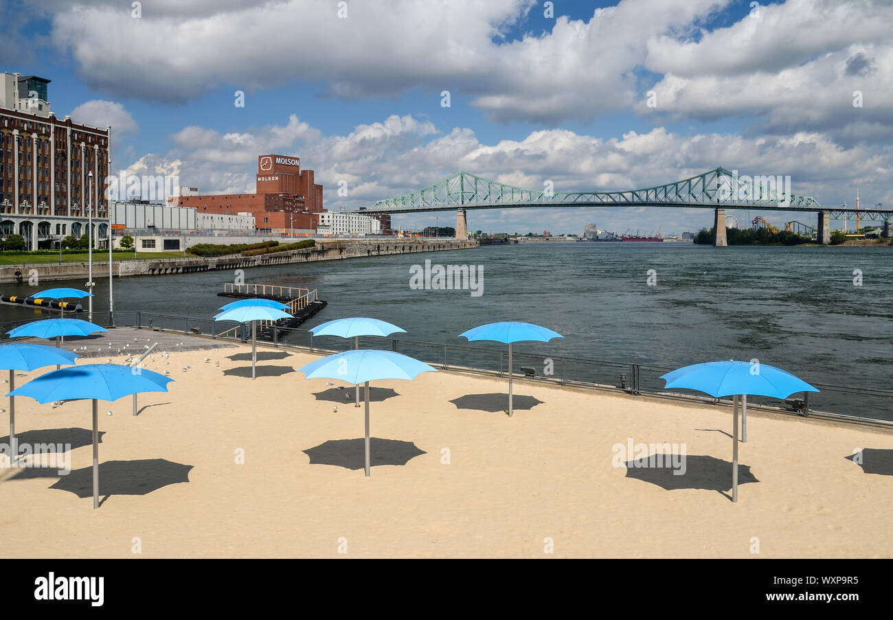 MONTREAL, KANADA - 16. SEPTEMBER 2014: Clock Tower Strand mit Blauer Sonnenschirme am Eingang des alten Hafen von Montreal. Stockfoto