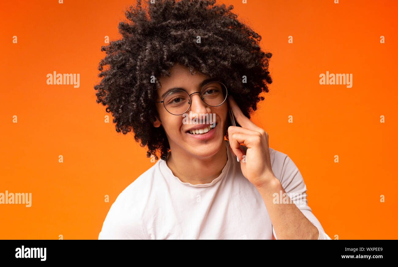 Super schwarze Kerl Gespräch am Handy, orange Hintergrund Stockfoto