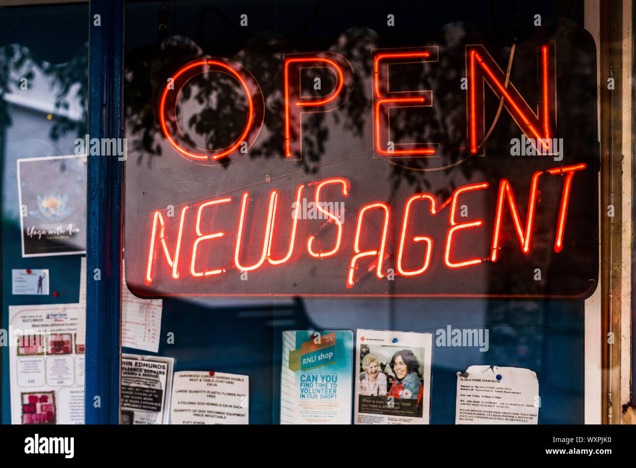 Newsagent Shop Neon Sign - ÖFFNEN SIE die NEWSAGENT-ANMELDUNG im Fenster eines Newsagents-Shops in Großbritannien Stockfoto