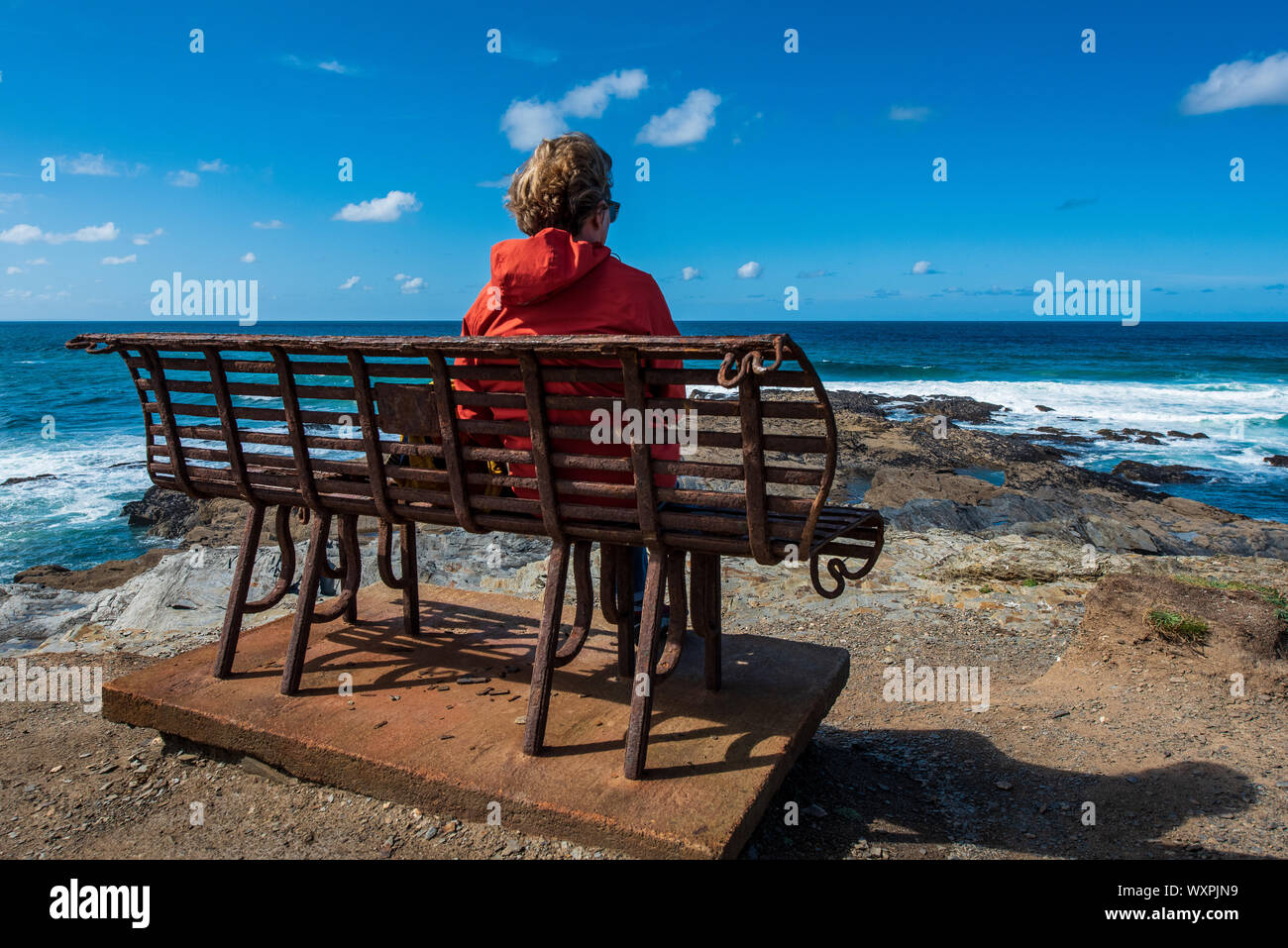 Frau alleine im meer Meditation. Eine Frau sitzt auf ihrem eigenen mit Meerblick. Stockfoto