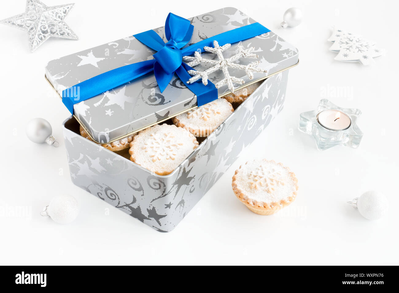 Hohe Betrachtungswinkel von mince pies in Weihnachten Cookie Zinn mit Teelicht und Weihnachten Dekoration. Stockfoto