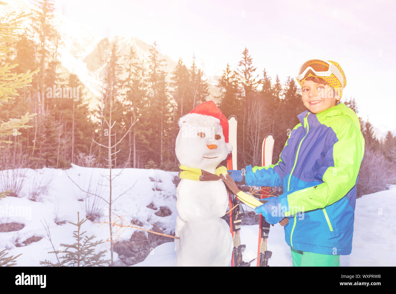 Junge auf Schal, Schneemann mit Weihnachtsmütze Stockfoto