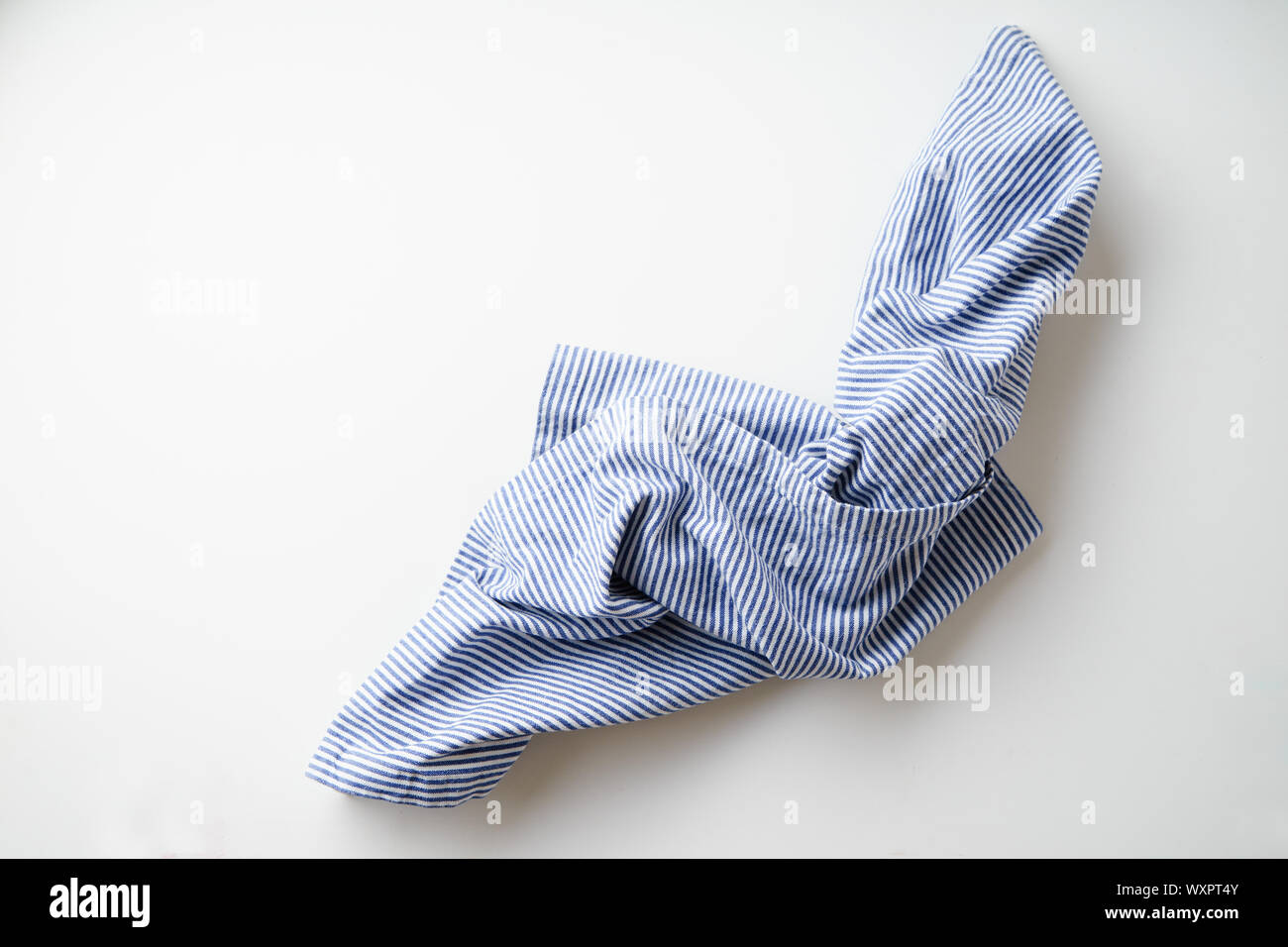 Blau und Weiß textil Serviette auf weißem Hintergrund gefaltet gestreift. Foodstyling element Stockfoto