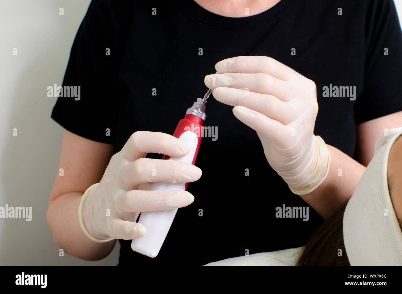 Kosmetikerin in weißen Handschuhen Holding dermis Stempel Electric Pen, dermapen Werkzeug für die Nadel Mesotherapie Behandlung schließen oben. ästhetische Verfahren Stockfoto