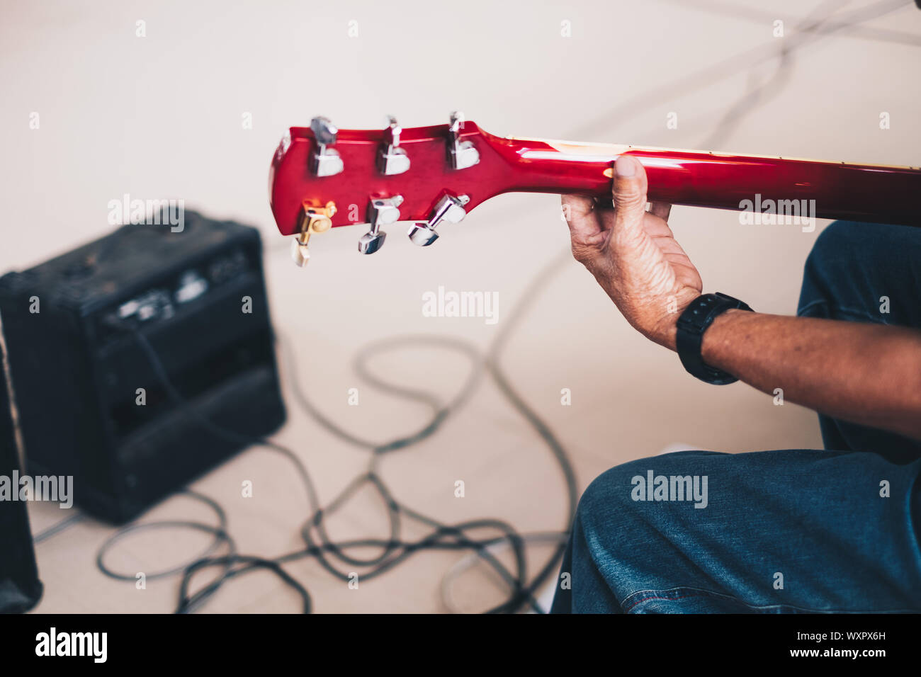 Zurück Blick auf die Hand des Menschen spielen eine E-Gitarre. Selektive konzentrieren. Kopieren Sie Platz. Stockfoto