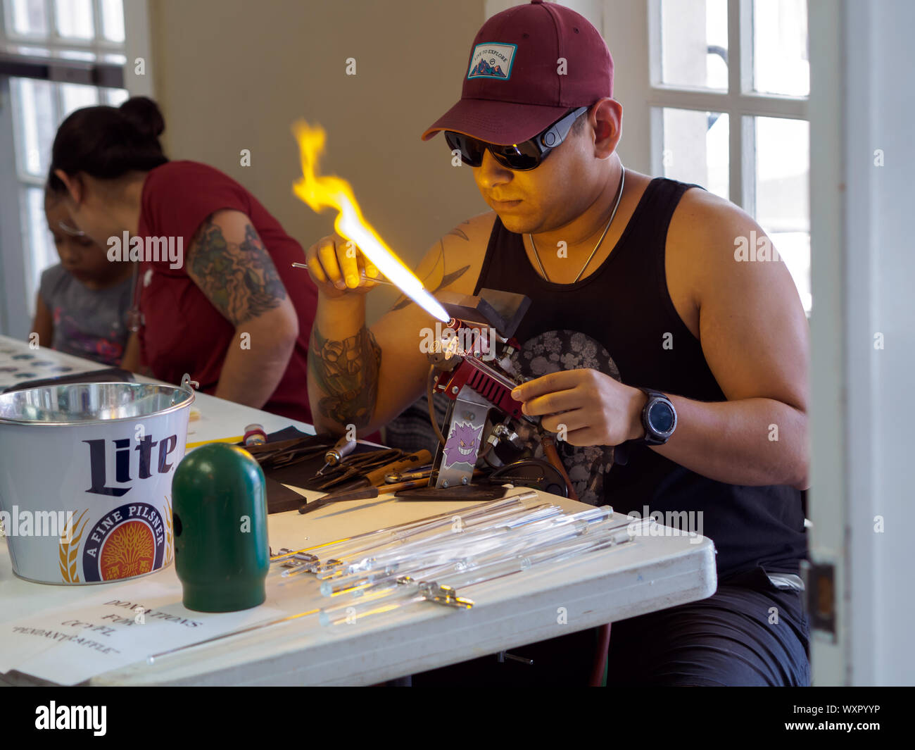 Ein männlicher lampworker verwendet eine Fackel zu Hitze Glasröhren beim Erstellen von Glas Art Arts Alive Festival 2019 in Corpus Christi, Texas USA. Stockfoto