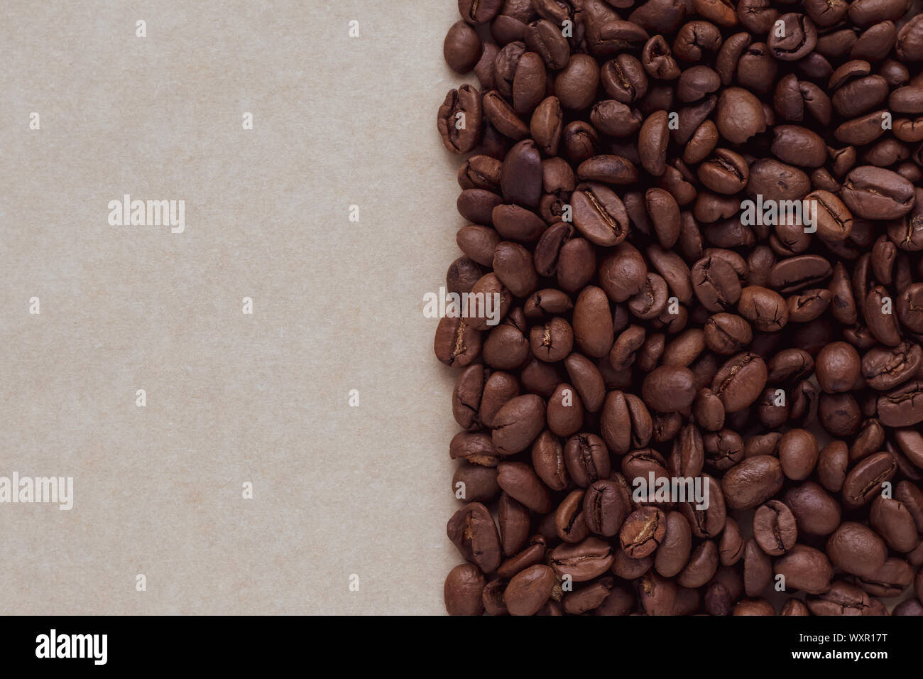 Vintage abstrakte Muster mit schwarzen Kaffee Bohnen auf braunem Papier Hintergrund. Kopieren Sie Platz für Text. Natürliche Kulisse, Karton Textur. Stockfoto