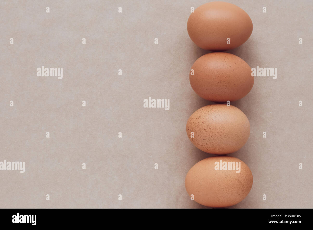 Abstrakte Muster mit braunen Eiern auf den Tisch, Papier Hintergrund. Kopieren Sie Platz für Text. Natürliche rustikale Kulisse, Textur. Gesundes Essen. Stockfoto