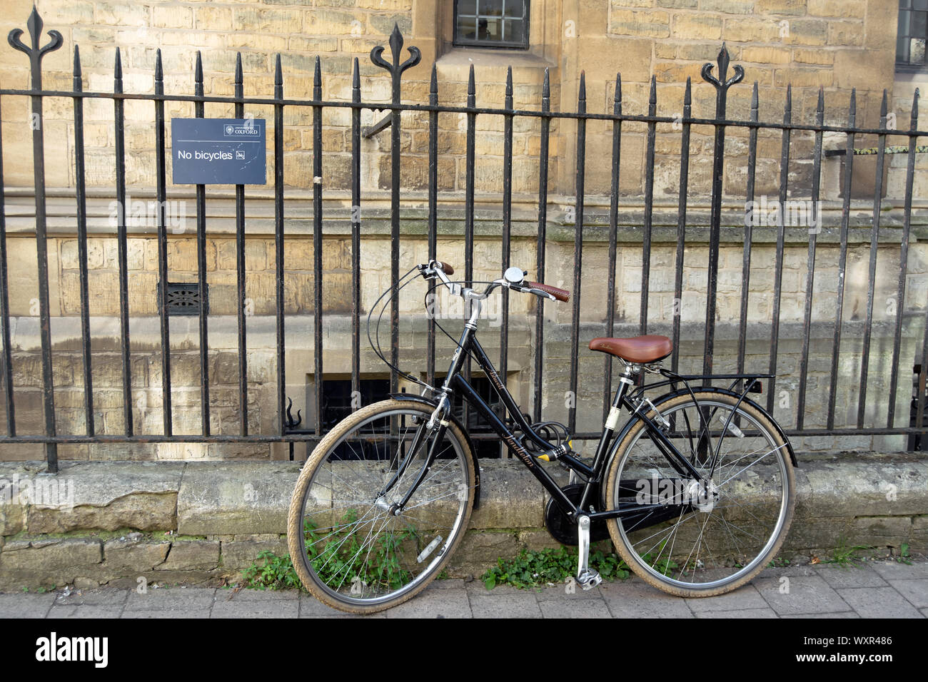 Ein Fahrrad am Geländer neben einer Universität Oxford keine Fahrräder, im merton Lane, Oxford, England Stockfoto