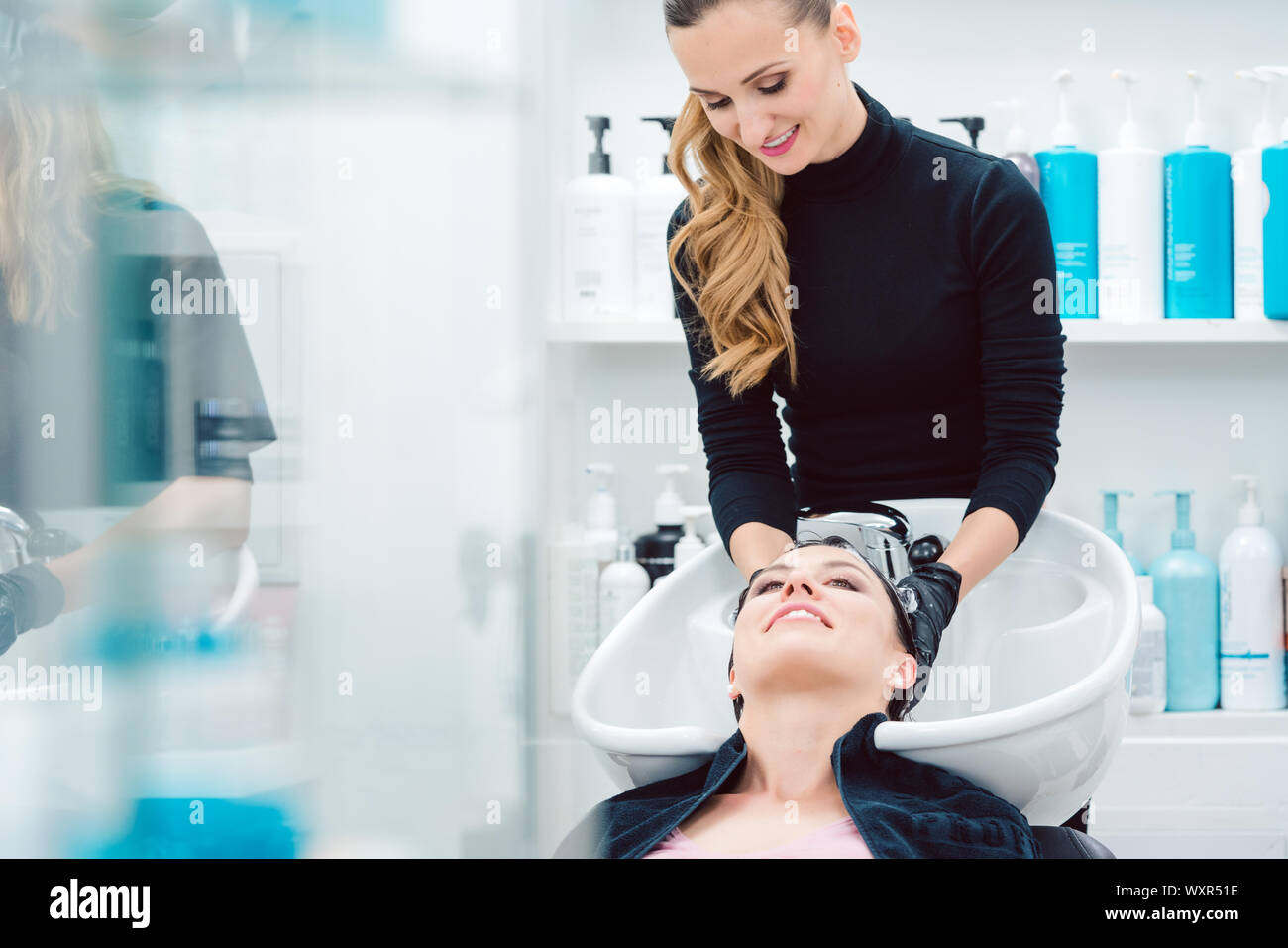 Artisan Friseur fleißig Haare waschen von Kunden Frau Stockfoto