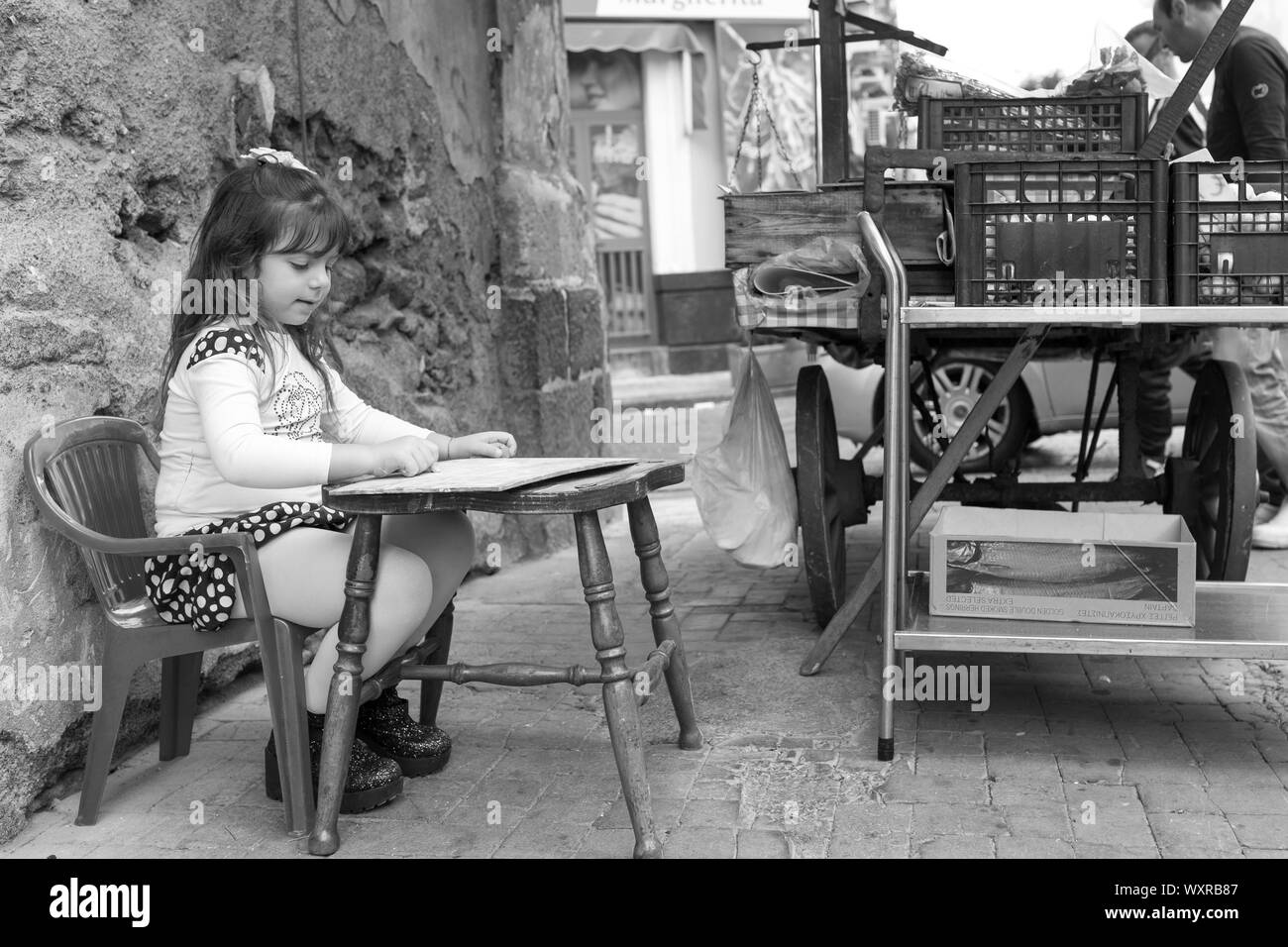 Catania/Italien - Mädchen auf der Straße, während ihr Vater waren verkauft aus dem Stall. Schwarz-weiß Foto. Stockfoto