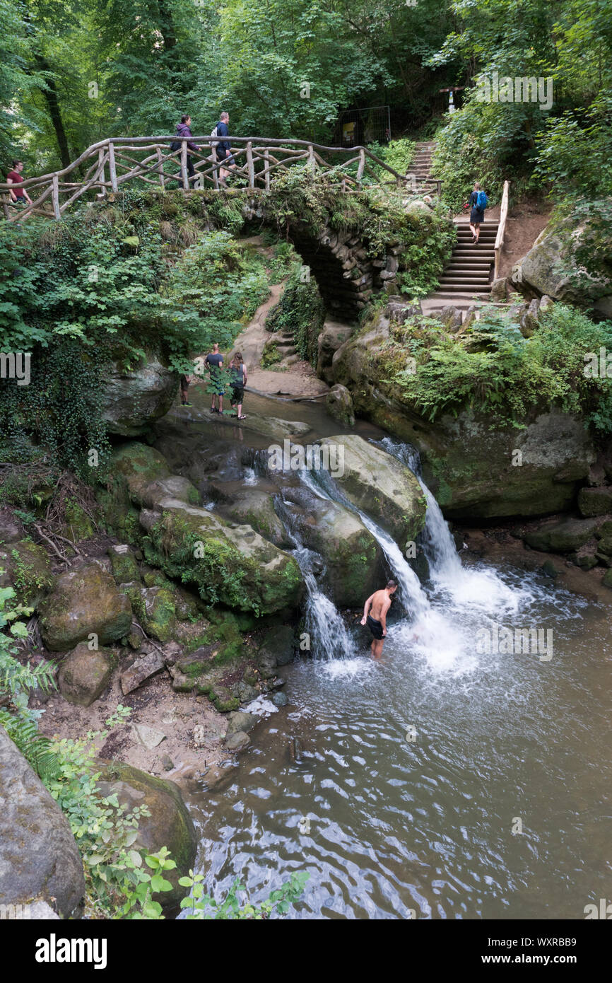 Heringer Millen, Müllerthal/Luxemburg, 11. August 2019: touristischen Besuch und Schwimmen am idyllischen Wasserfall Schiessentuempel im Müllerthal Stockfoto